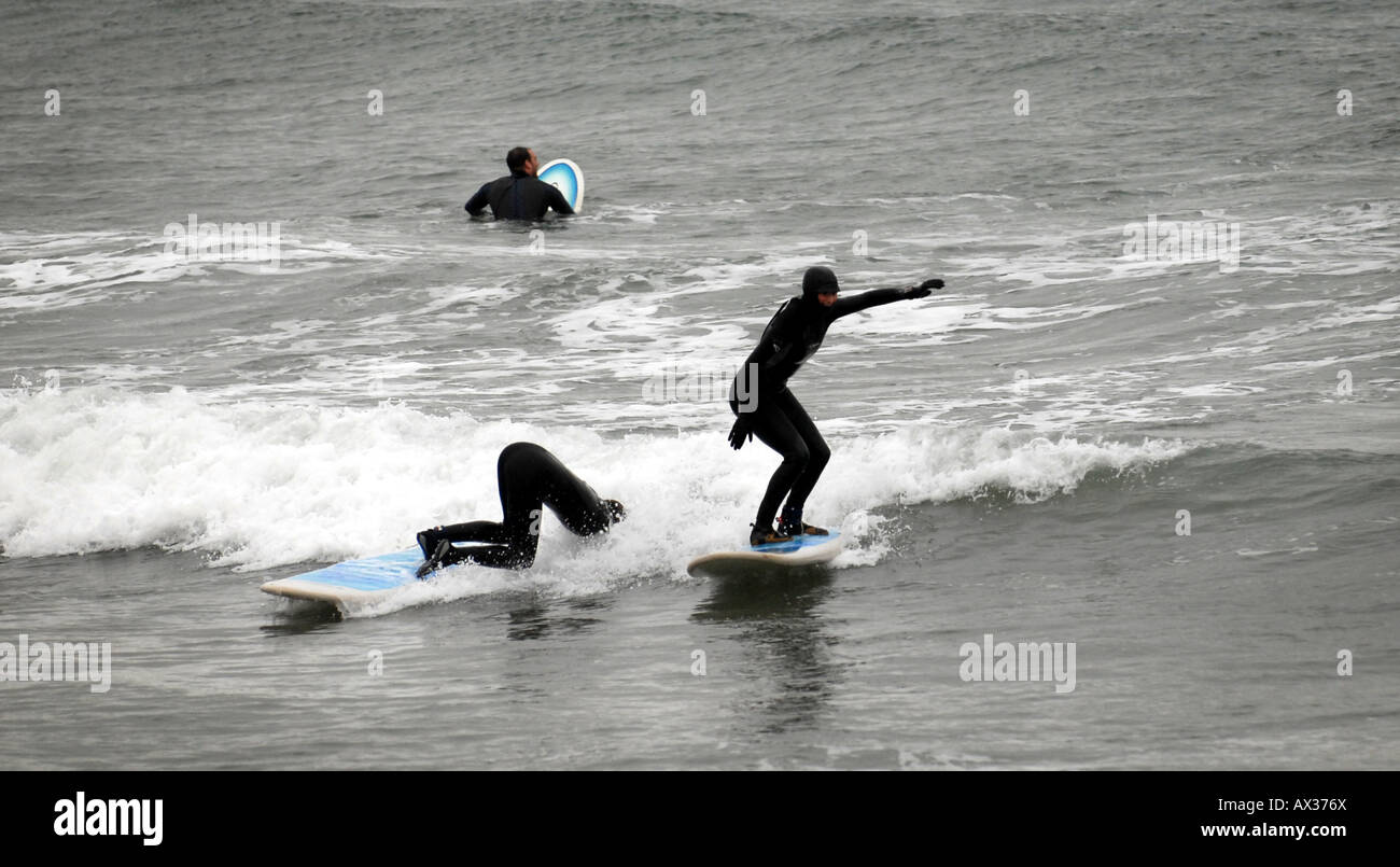 SURFERS LEARNING TO SURF  AND FALL AT A  SURF SCHOOL IN BIGBURY ON SEA,DEVON,ENGLAND.UK Stock Photo