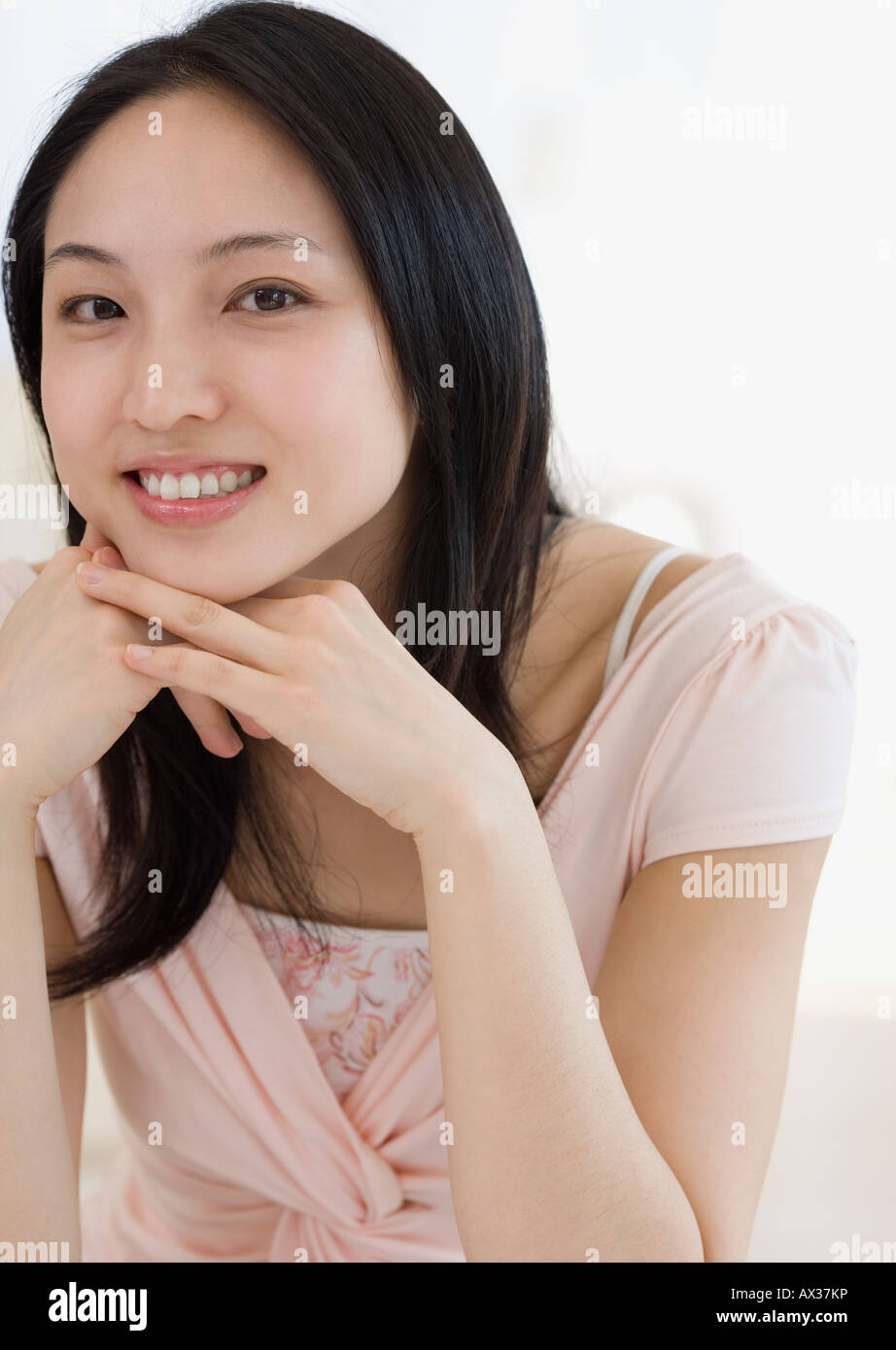 Asian woman with chin on hands Stock Photo - Alamy