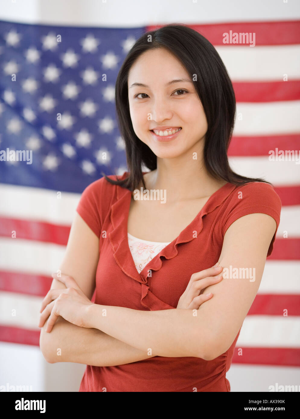 Asian woman standing in front of American flag Stock Photo
