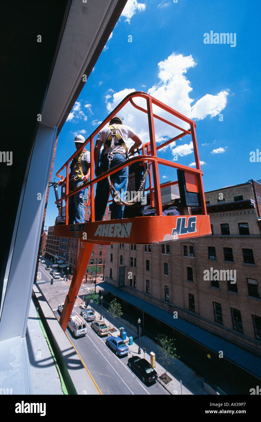 Construction workers in cherry picker outside high rise building Denver Colorado USA Stock Photo