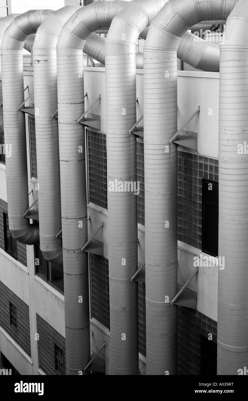 Giant ventilation ducts crawling up the side of a building. Stock Photo