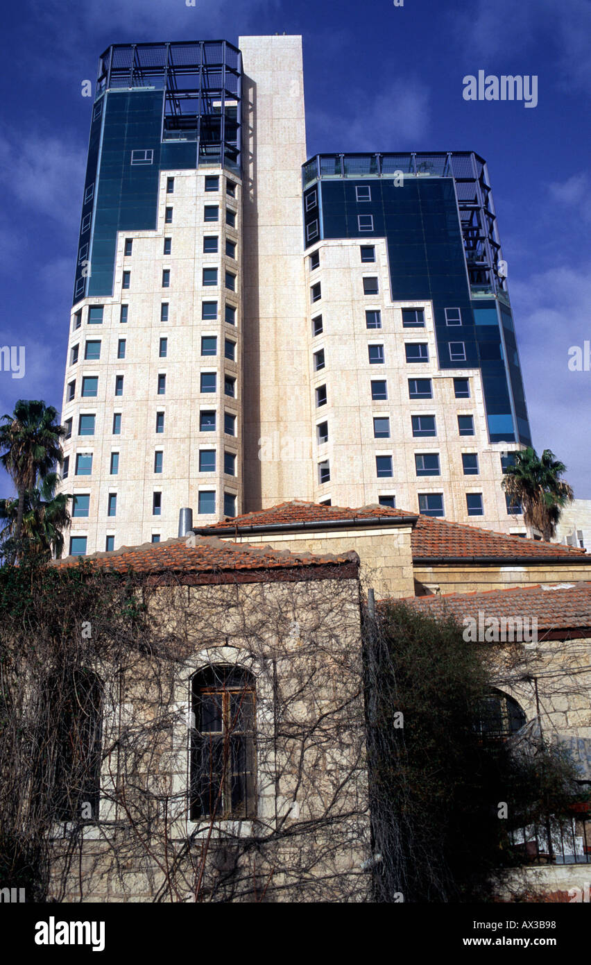 A modern office building stands in stark contrast to a a rundown