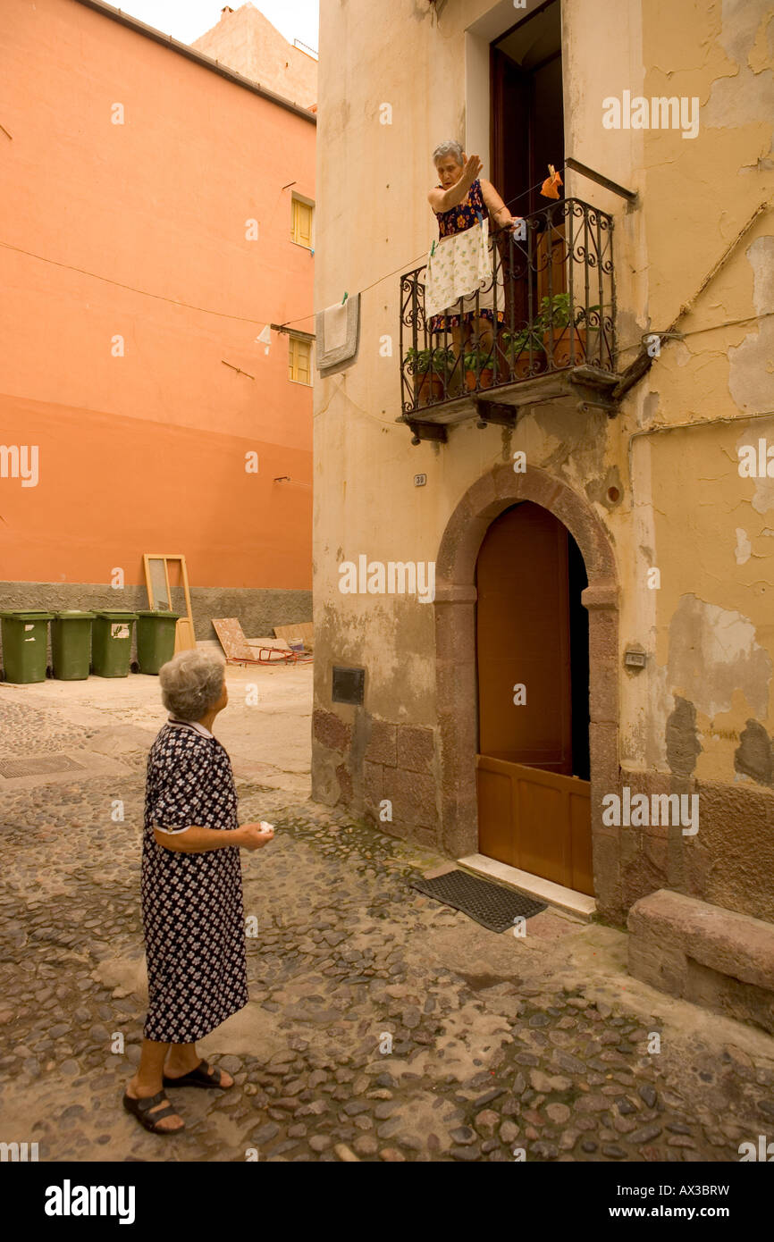 two old ladies talking to each other from the balcony to the street in Bosa Stock Photo