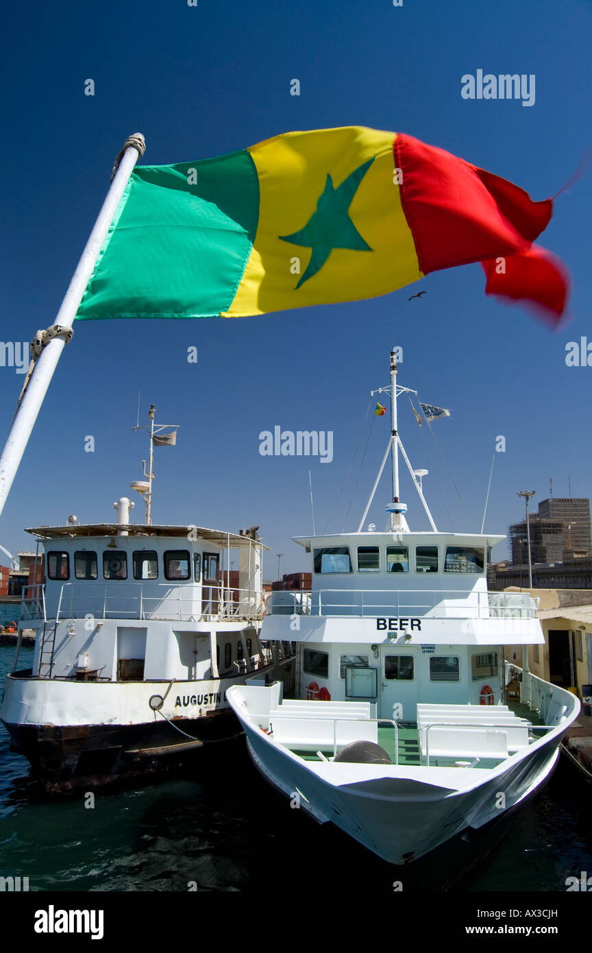 Travel, Senegal, Dakar, Senegalese national flag flying over motor boats in port, Stock Photo