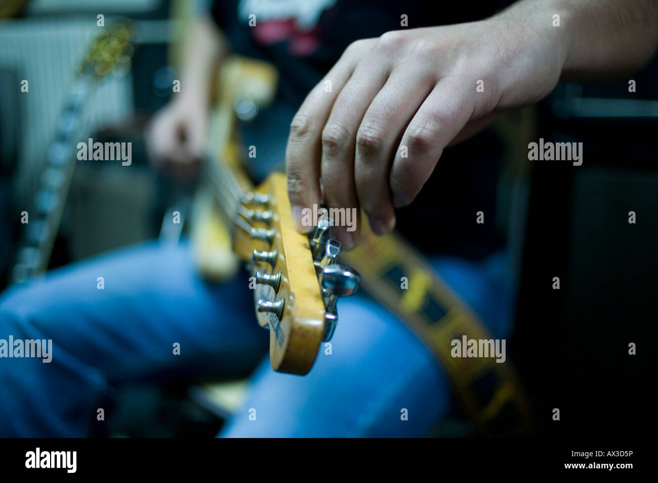 a musician tuning his electric guitar inside a studio Stock Photo Alamy