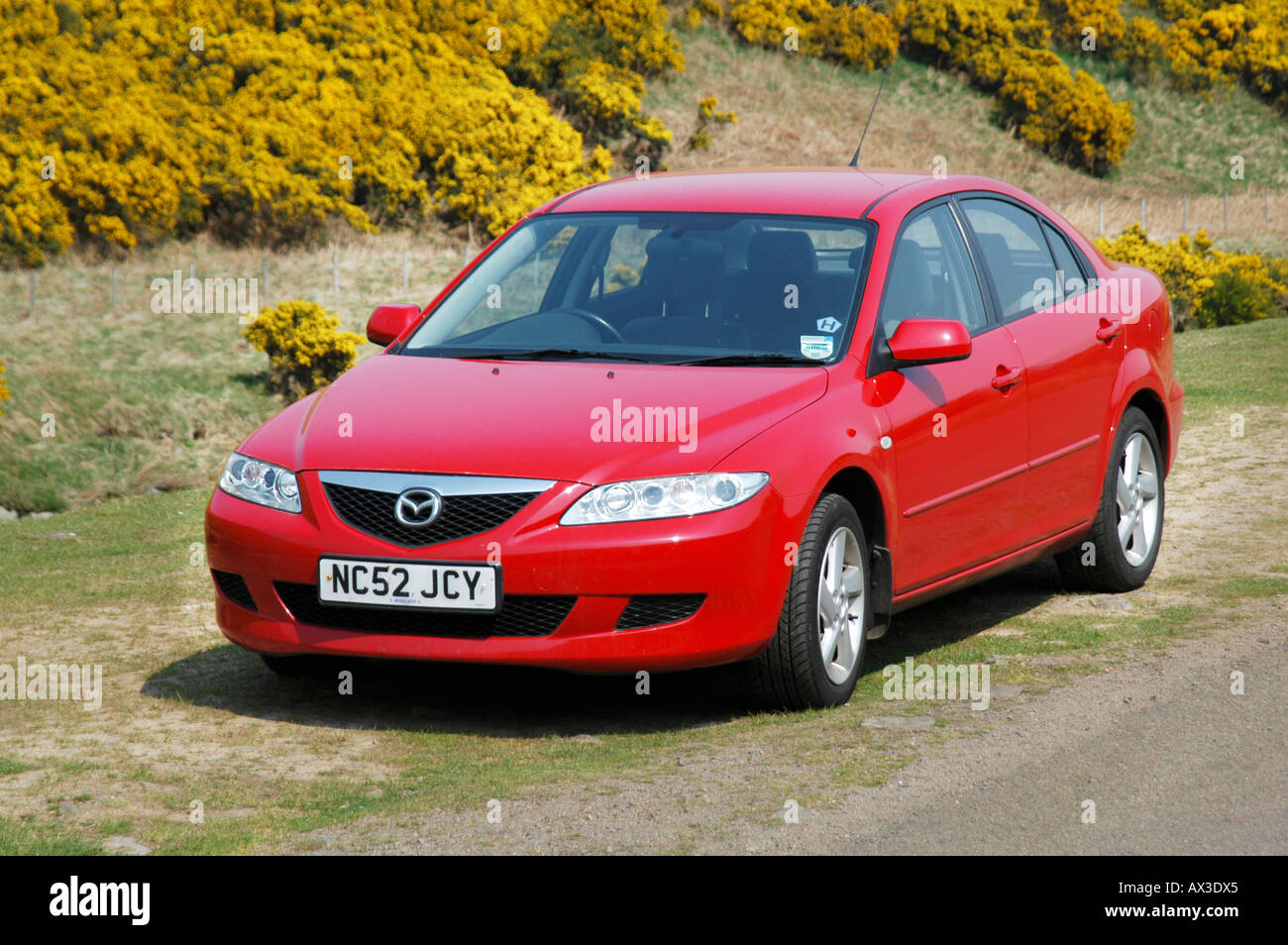 Red Mazda 6 saloon car parked at the side of the road in the countryside in the UK. Stock Photo