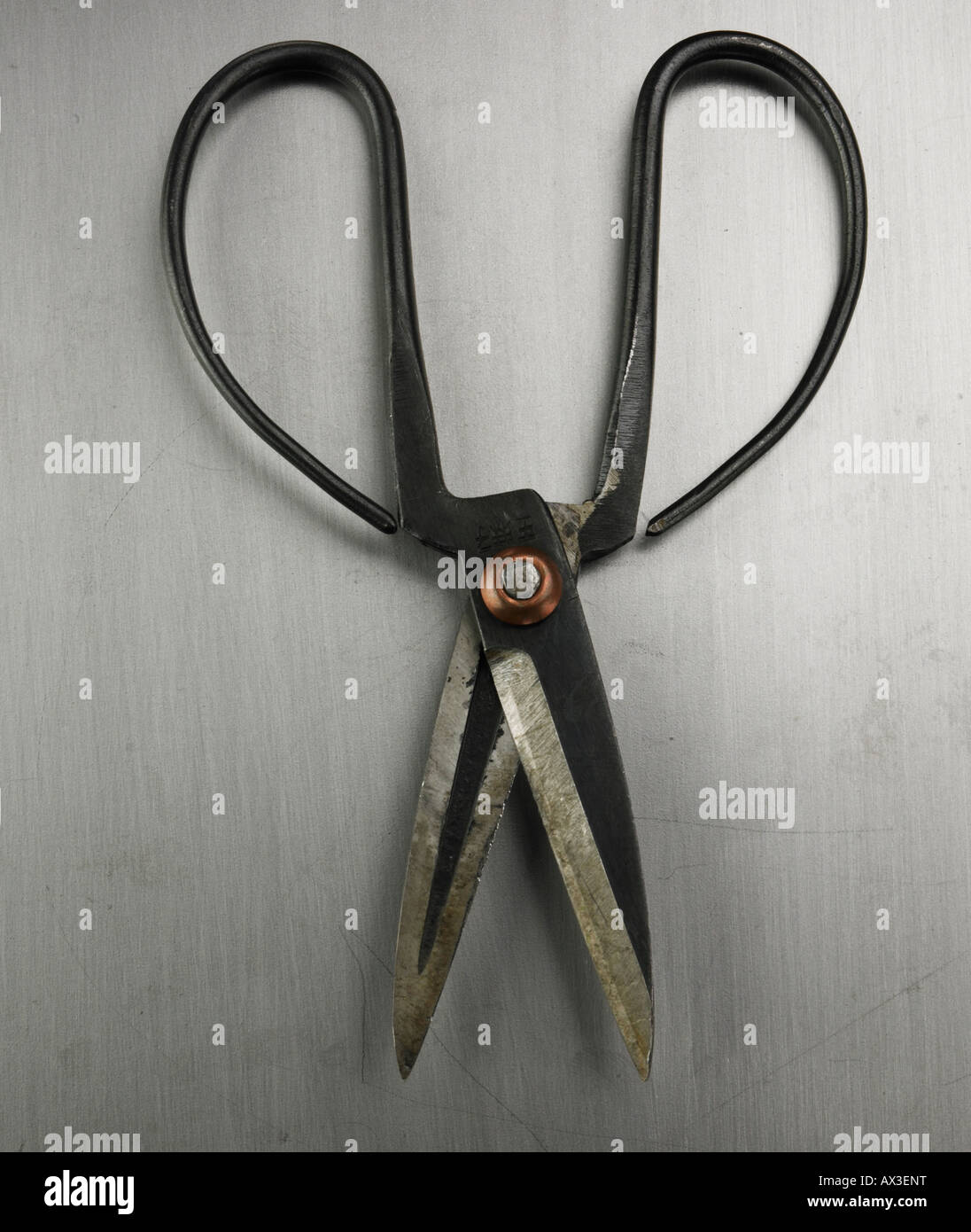 Pair of vintage Japanese scissor shears on a clean stainless steel surface. Stock Photo