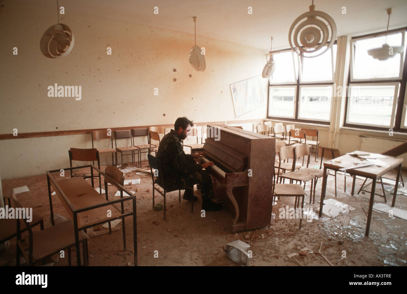 A man in Sarajevo plays a piano in the classroom where he was a teacher  before the civil war Stock Photo - Alamy