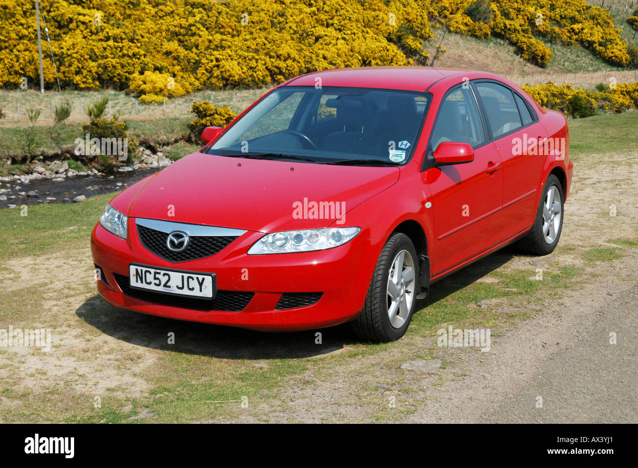 Red mazda 6 saloon car parked at the side of the road in the countryside in the UK. Stock Photo