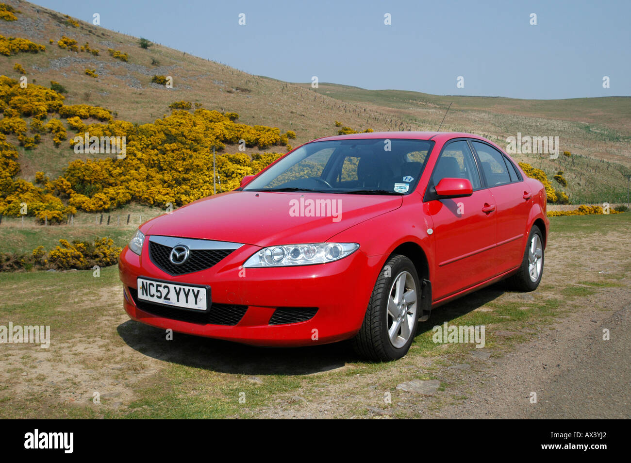 Red Mazda 6 saloon car parked at the side of the road in the countryside in the UK. Stock Photo