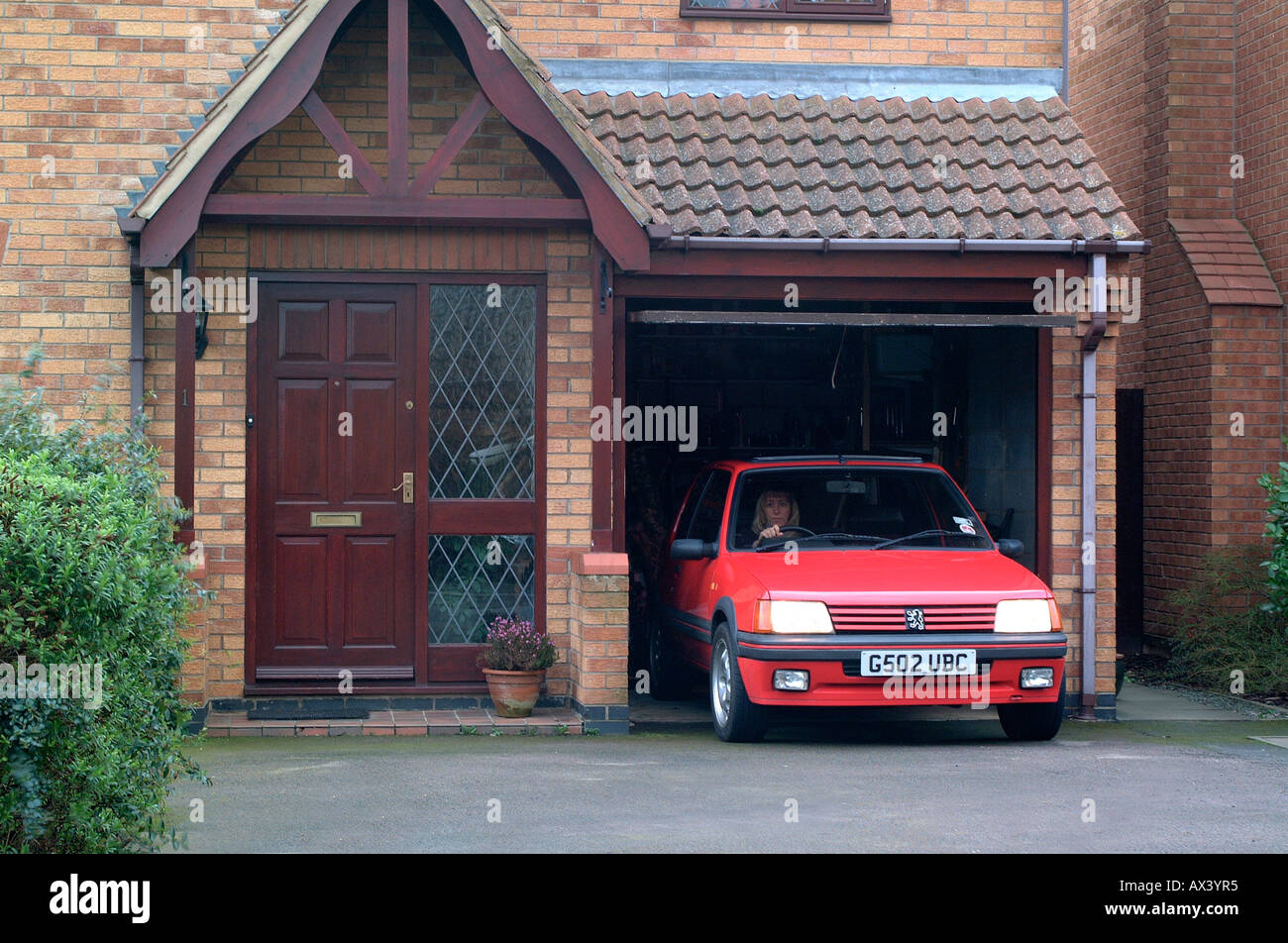 Lady driving a car out of a domestic garage Stock Photo Alamy