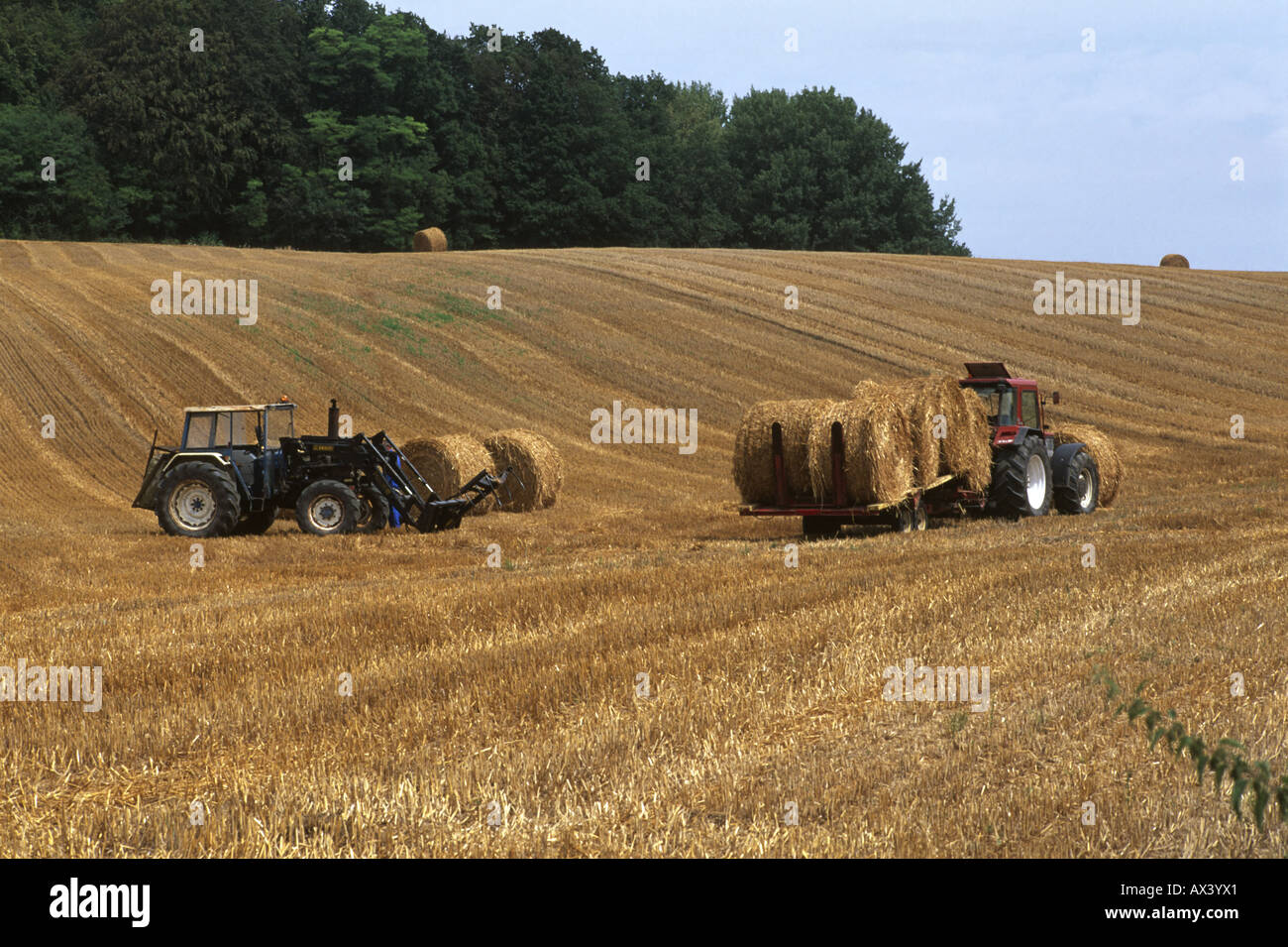 Two tractors harvesting haystacks in August, Picardy France Stock Photo ...