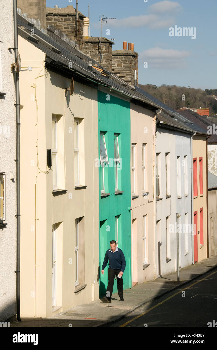 Man walking past a row of two up two down cheap affordable first time buyer type  terraced houses in Aberystwyth Wales UK Stock Photo