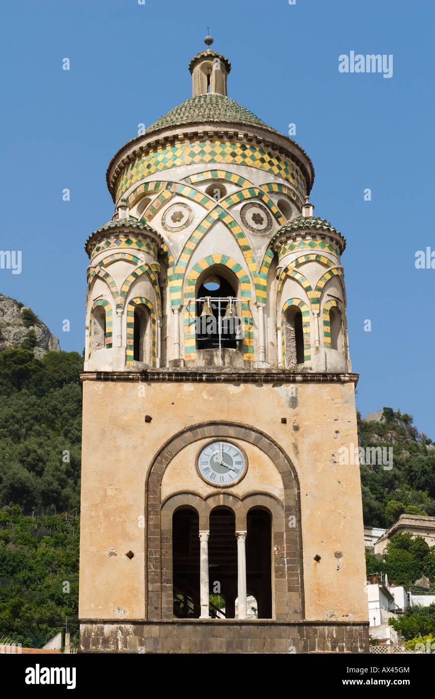 The cylindrical 12th century bell tower with yellow and green tiles above arches framing a set of bells in Amalfi, Campania, Italy Stock Photo