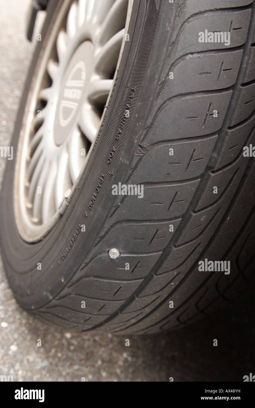 Automobile car tire tyre with sheet metal screw puncture causing a flat Stock Photo