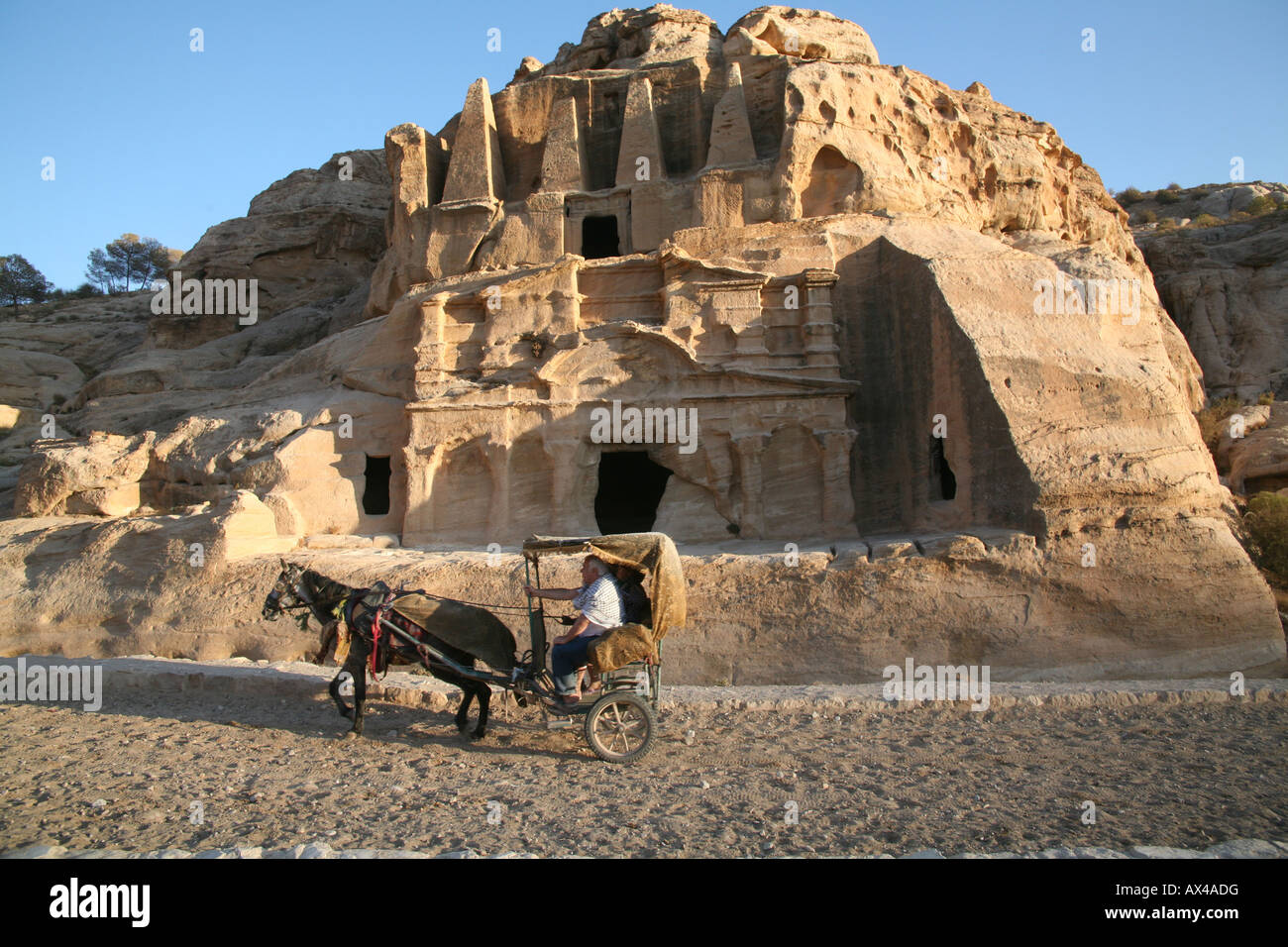A horse and carriage drive through Petra an ancient city in the southwest of Jordan hewn from towering walls of rock I Stock Photo