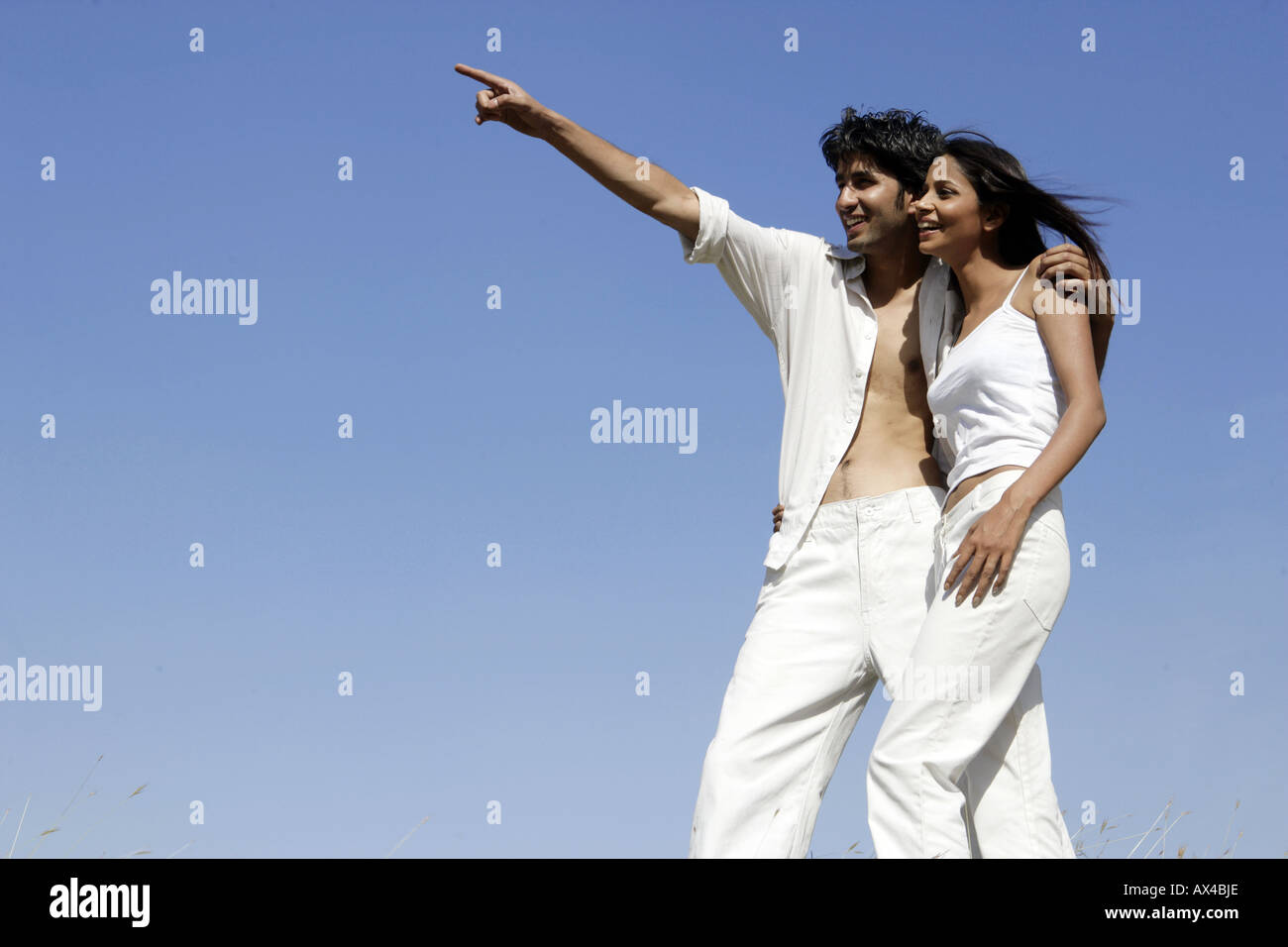 Young man standing with his girlfriend and pointing Stock Photo