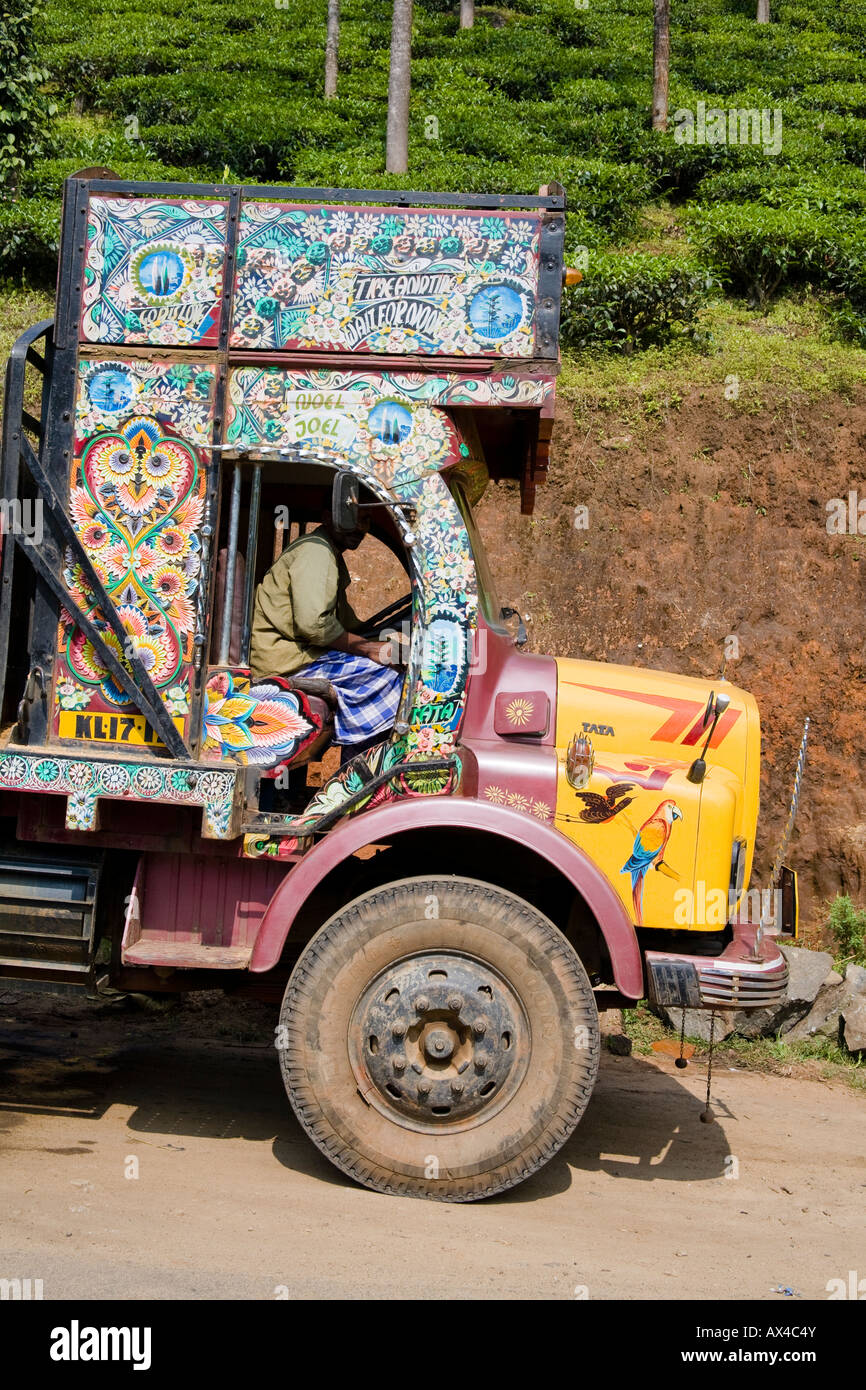 Colourful painted decorated truck, and driver, outside a tea plantation, Western Ghats, Kerala, India Stock Photo