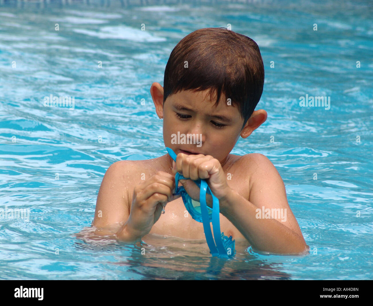 A young boy  with swimming gogles in the pool, spain Stock Photo