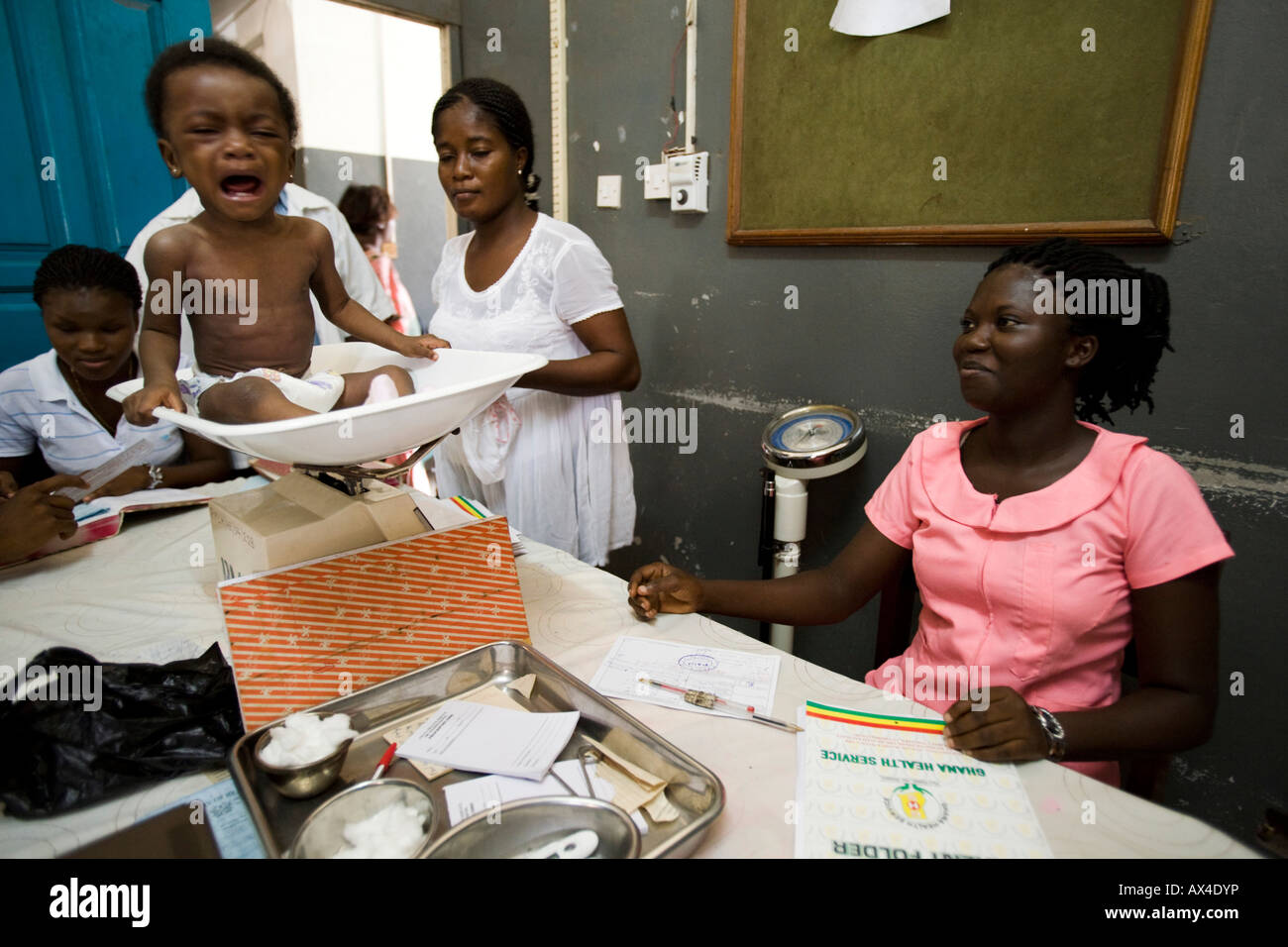 Medical staff weigh a child at hospital Stock Photo
