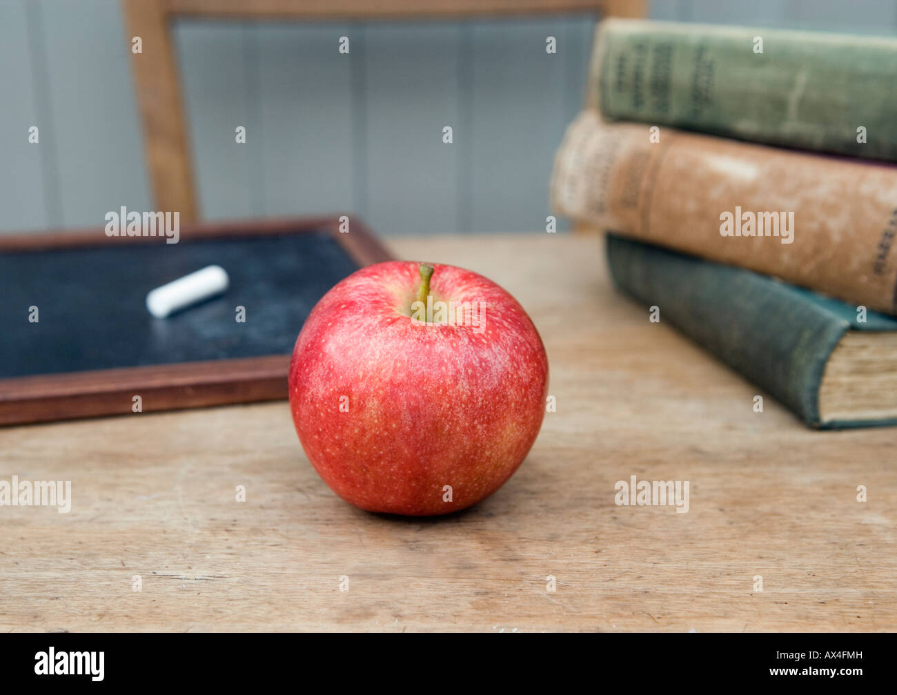 Teachers apple on a desk in a traditional classroom environment Stock
