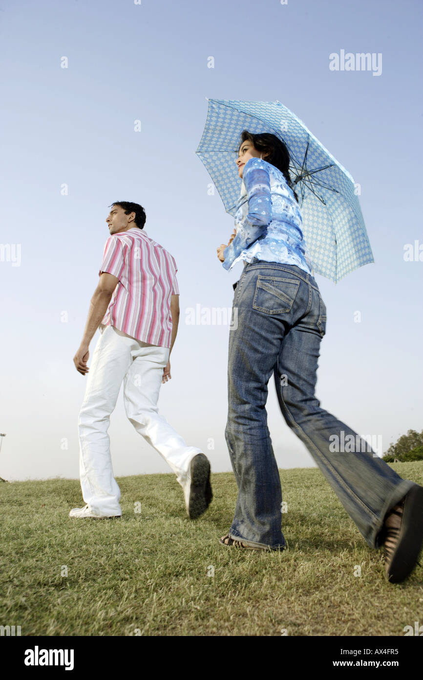 Rear view of a young couple walking in a park Stock Photo