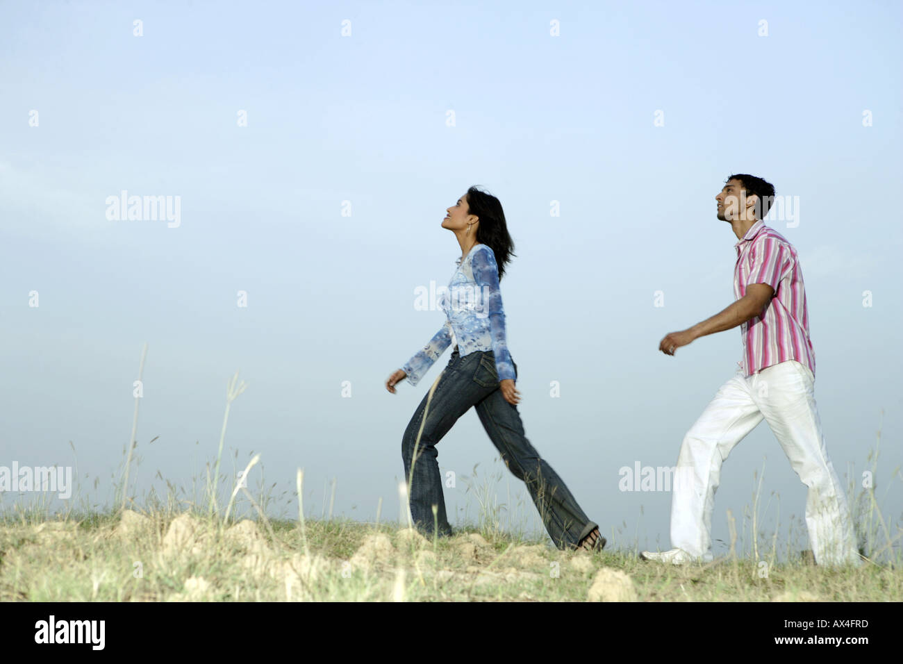 Side profile of a young couple walking in a park Stock Photo