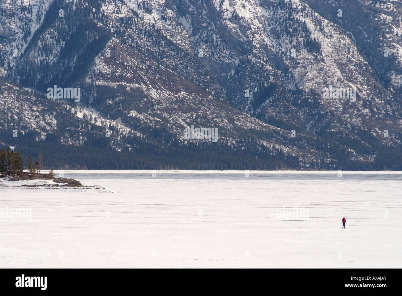 CANADA Alberta Banff Banff National Park a lone man snowshoeing on Lake Minnewanka Stock Photo