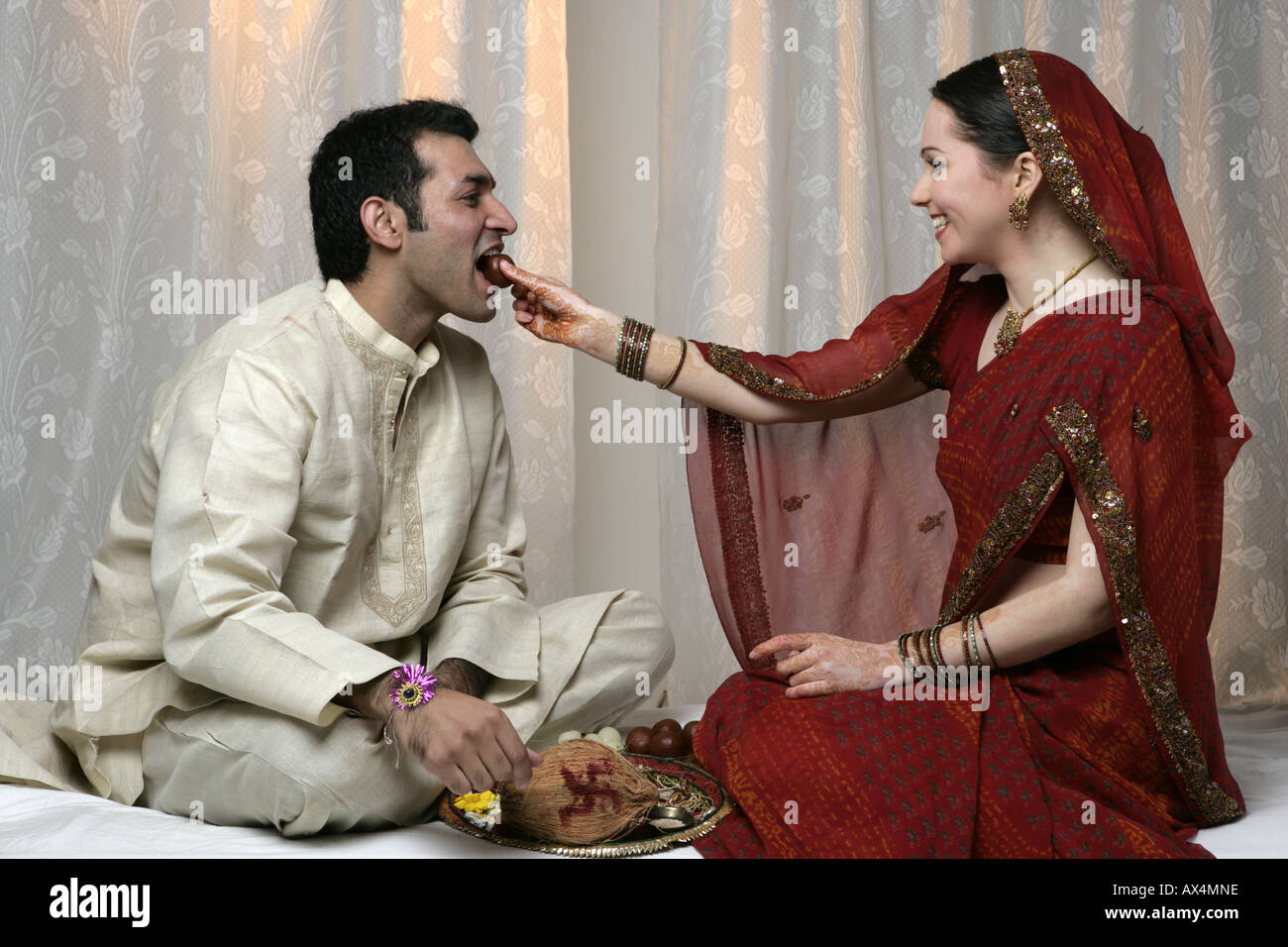 Brother and sister celebrating raksha bandhan and eating sweets Stock Photo