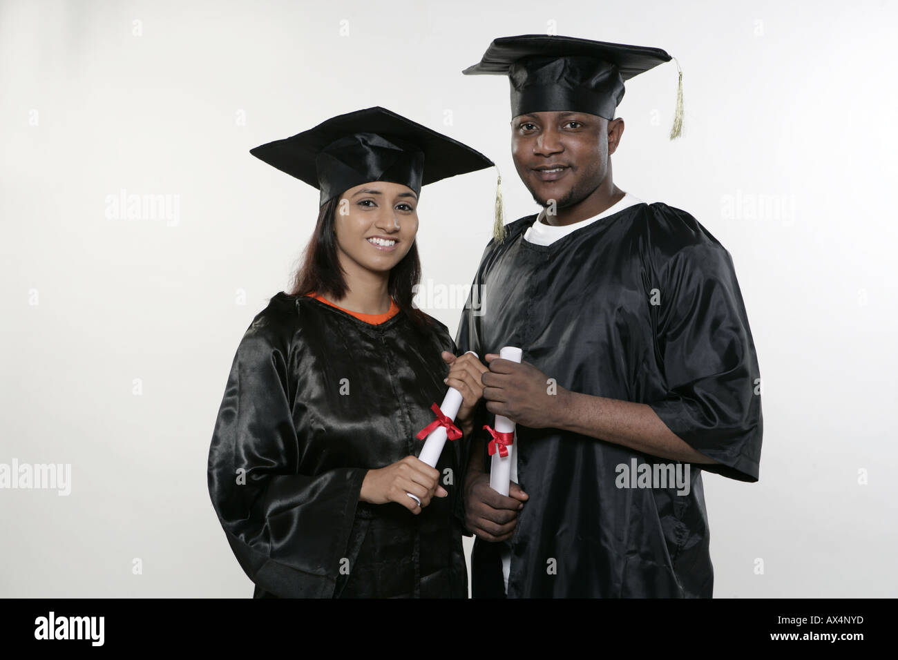 Portrait of two college students holding degree and smiling Stock Photo ...