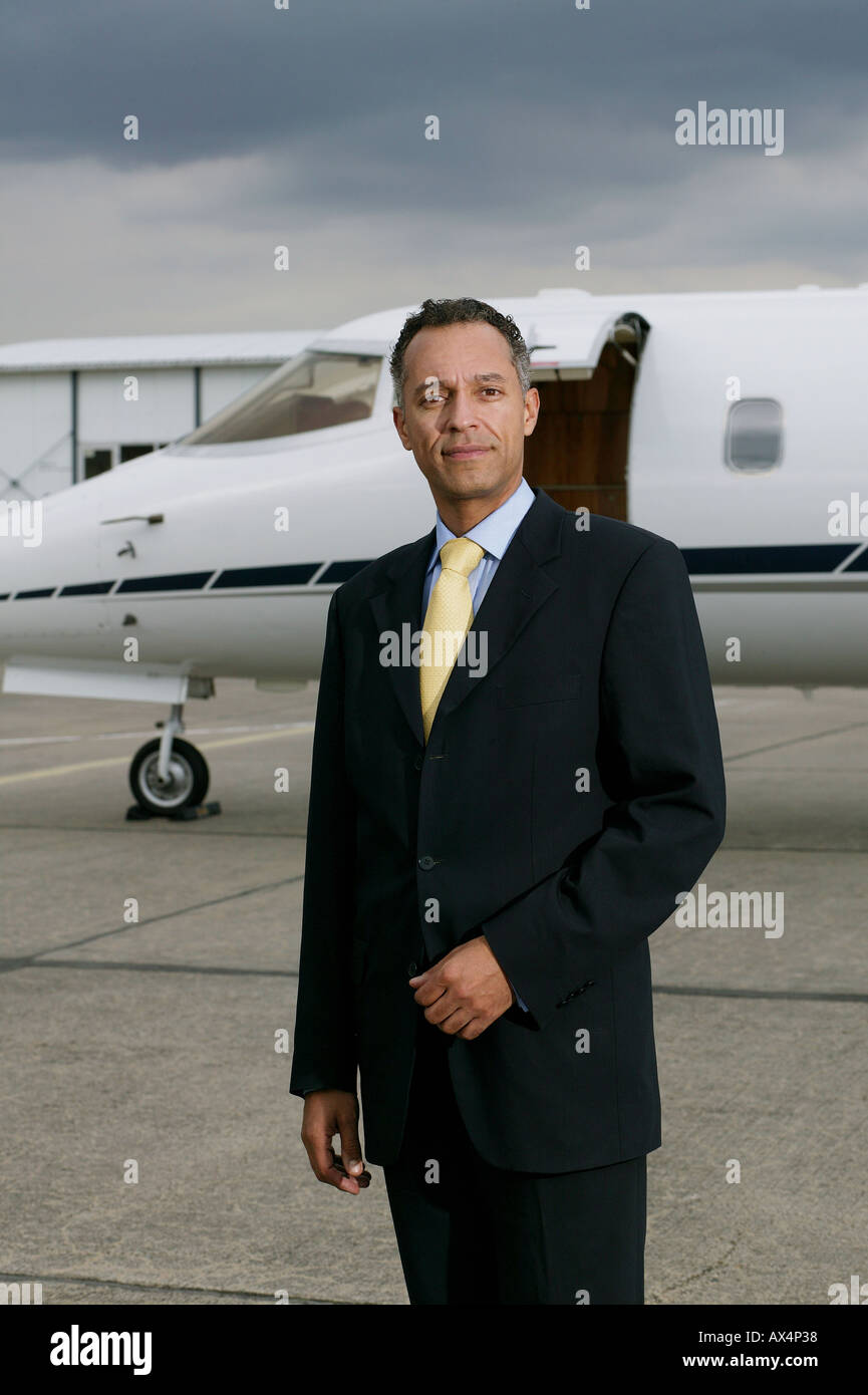 Businessman standing in front of a private airplane Stock Photo