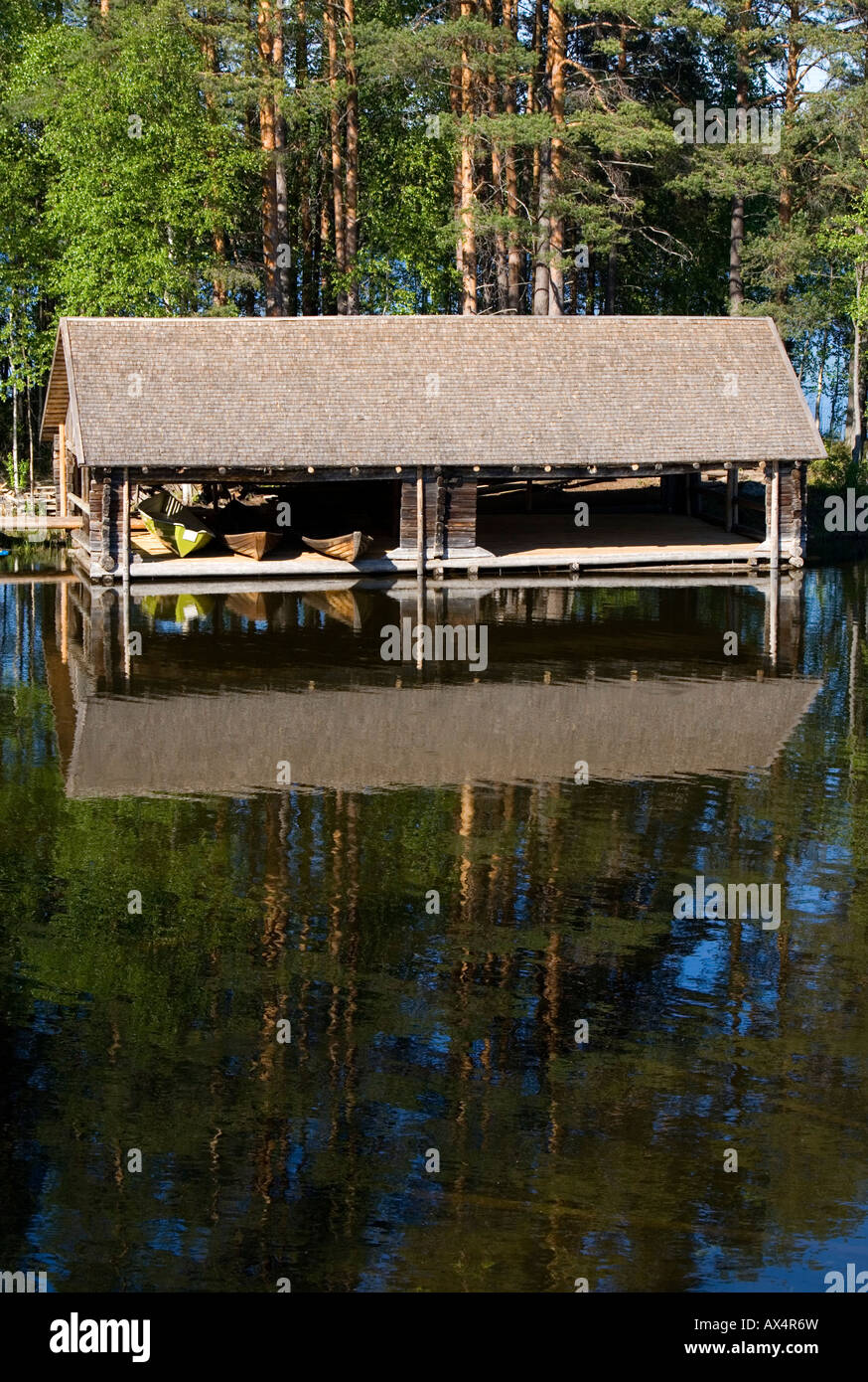 Wooden old-fashioned boathouse with rowboats / skiffs / dinghies at lake Konnevesi Finland Stock Photo