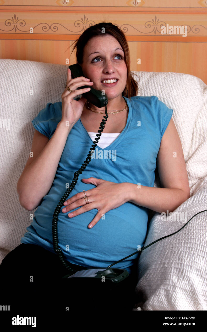 Young pregnant woman in labour on telephone Stock Photo
