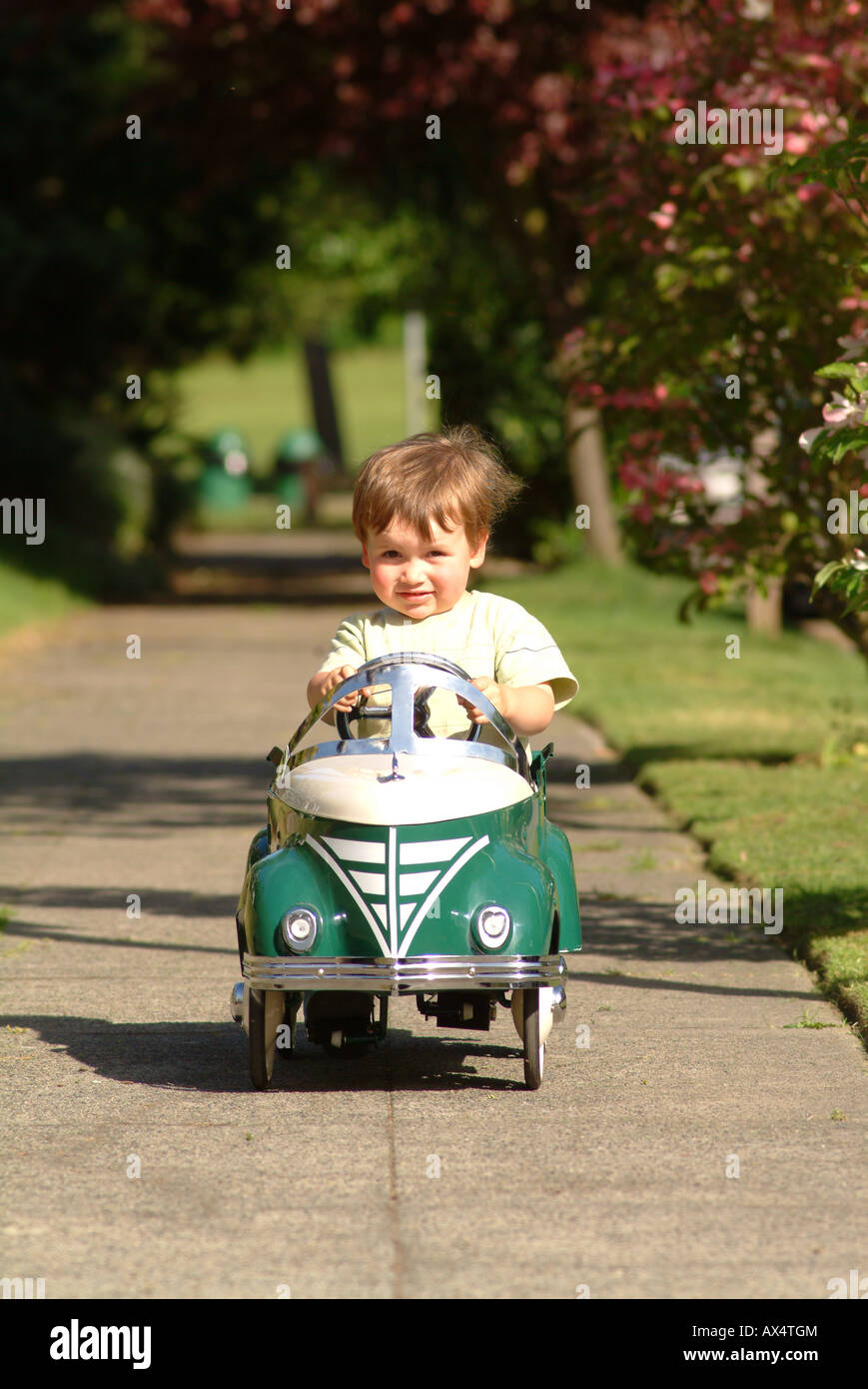 boy driving pedal car on sidewalk Stock Photo Alamy