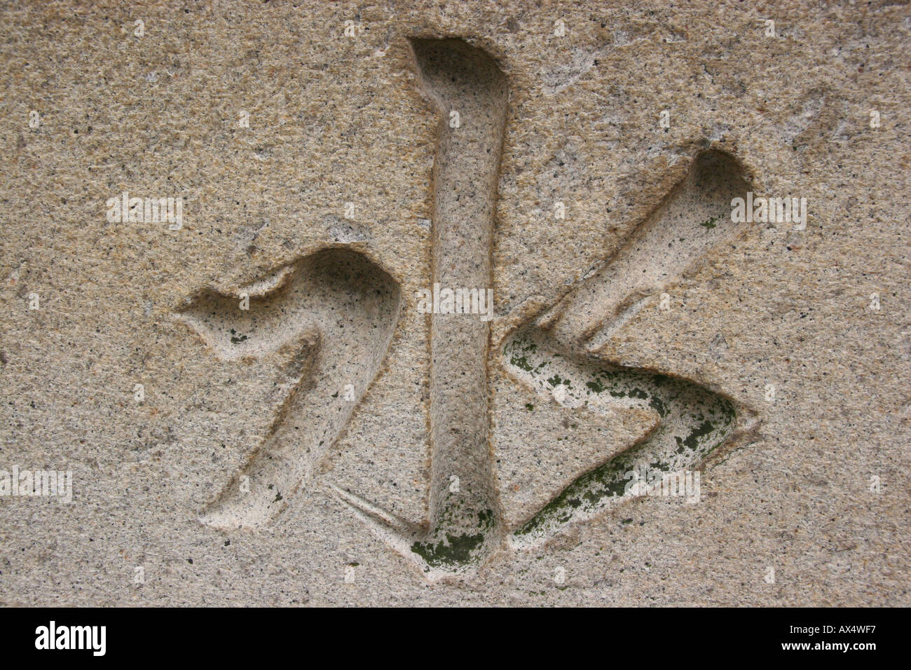 Chinese kanji character for water carved into a stone basin at a shinto shrine in Japan Stock Photo