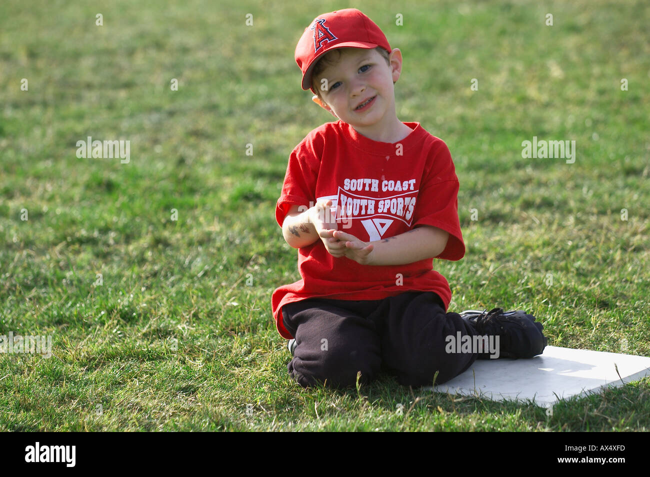 baseball boy sitting by base Stock Photo Alamy