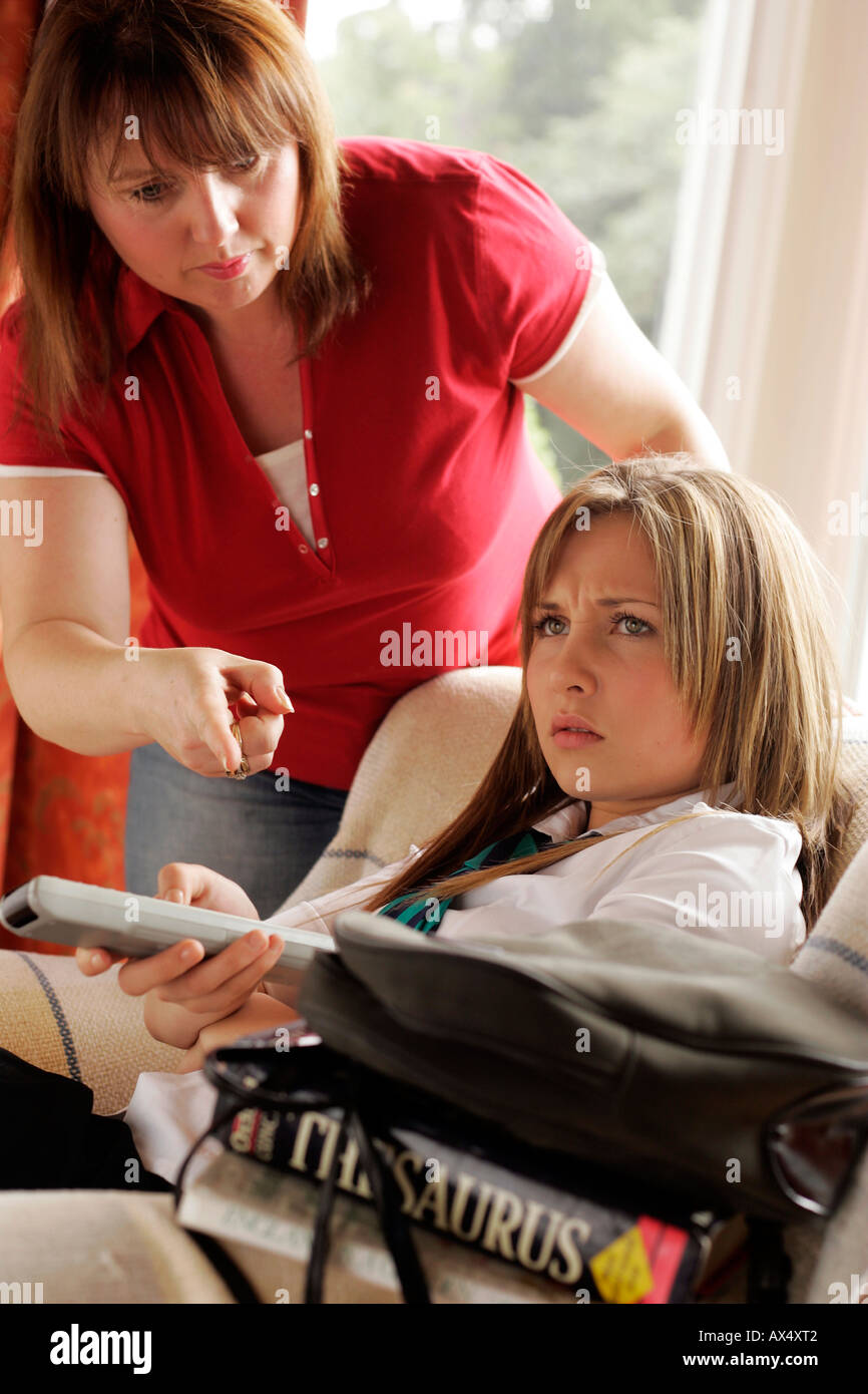 mother telling her teenage daughter to do her homework Stock Photo