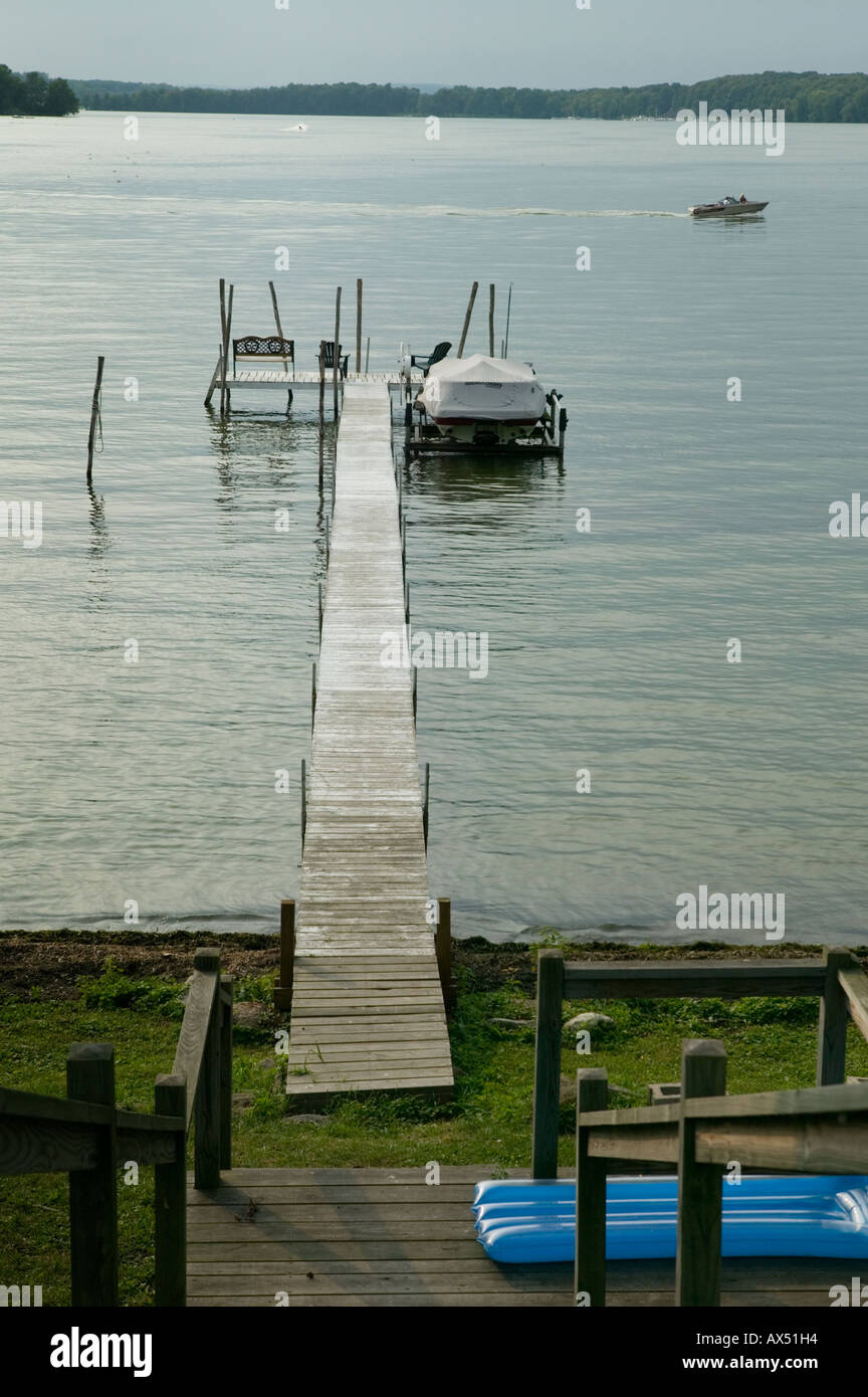 Boat passes by private dock Bemus Point Lake Chautauqua New York Stock