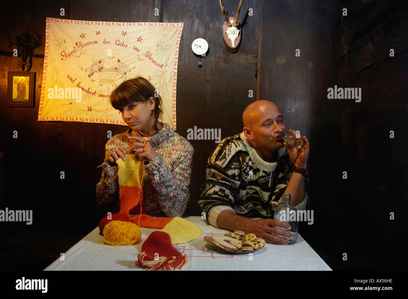 Mid adult couple sitting by table in alpine hut Stock Photo