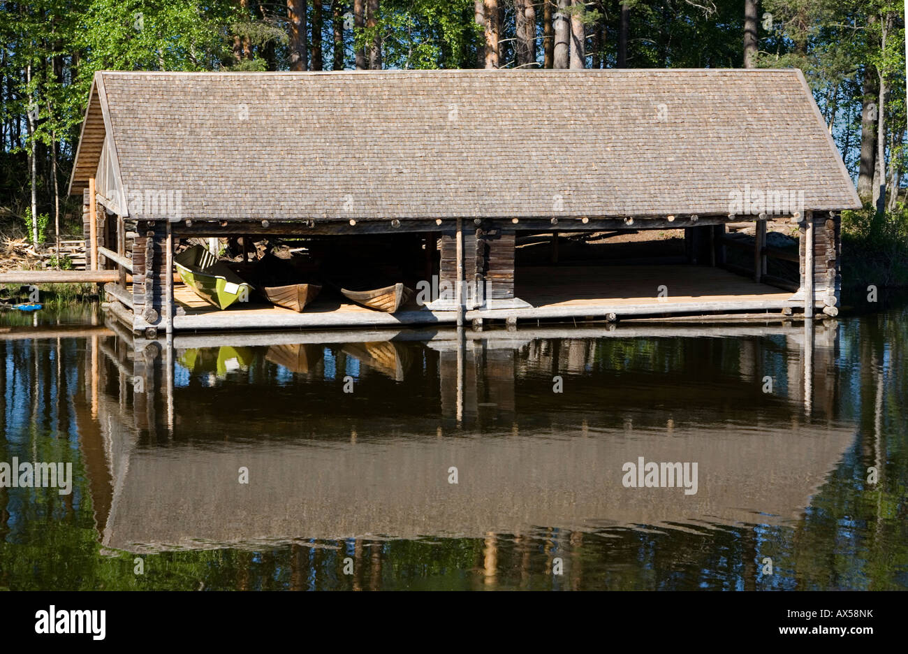 Wooden old-fashioned boathouse for rowboats and skiffs and dinghies / dinghy at lake Konnevesi Finland Stock Photo