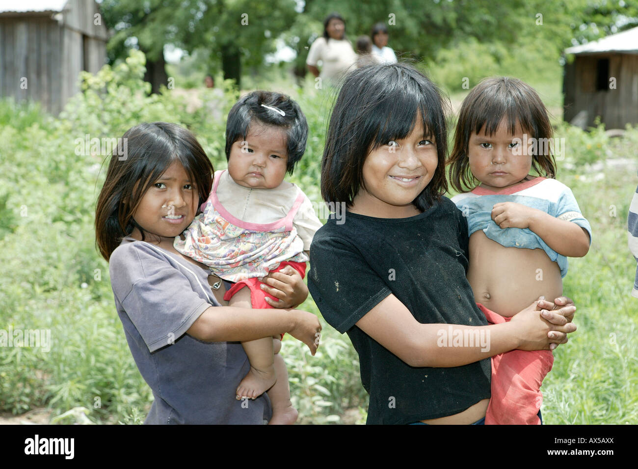 Two girls with children on their arms, Nivaclé Indians, Jothoisha, Chaco, Paraguay, South America Stock Photo