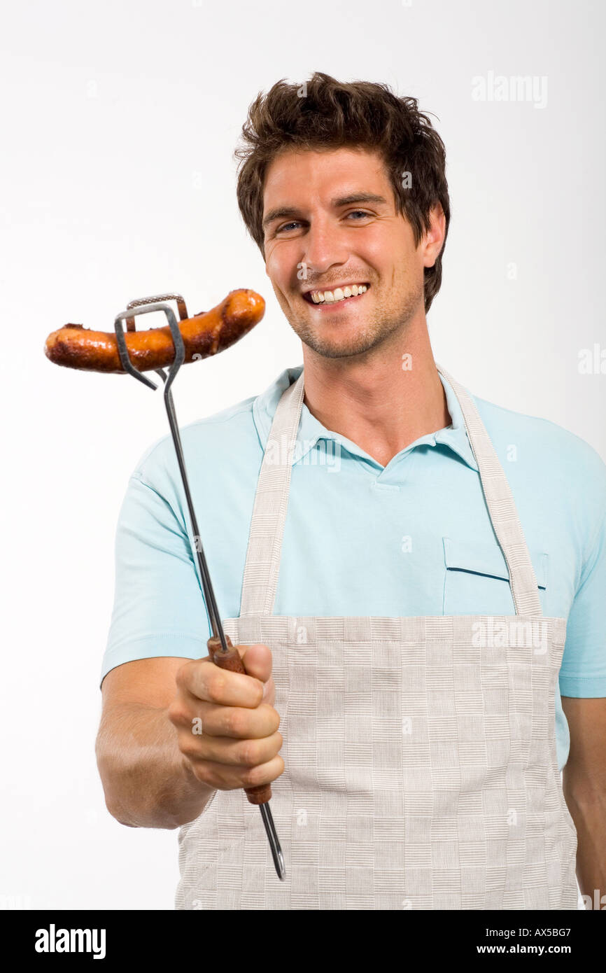 Young man with grilled sausage Stock Photo