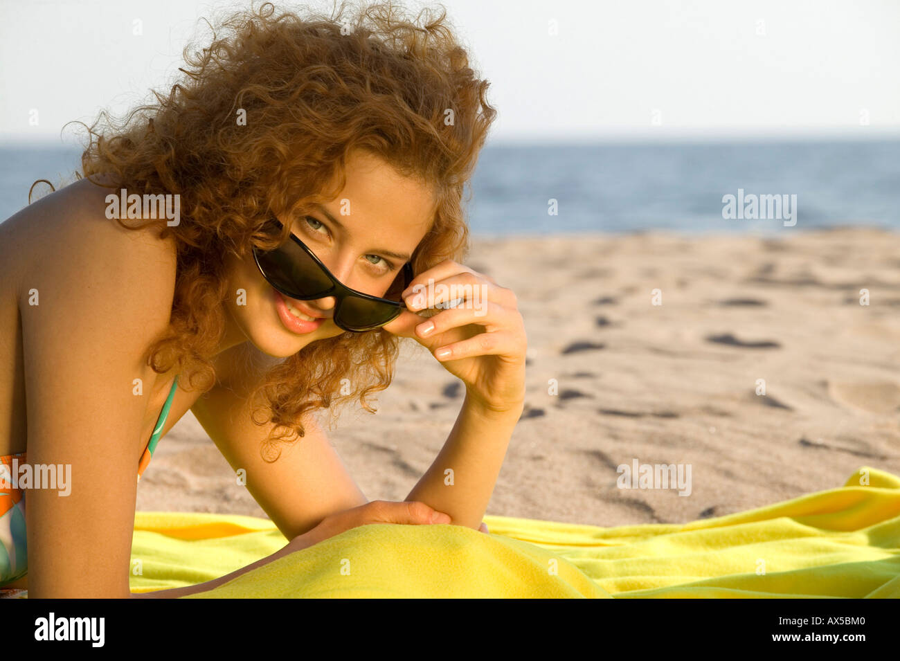 Young woman wearing sun glasses, relaxing on beach Stock Photo