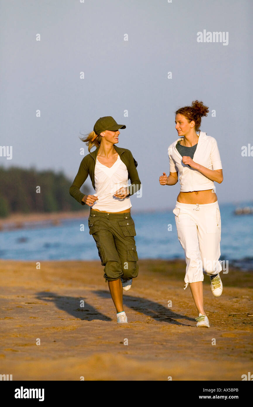 Two women jogging on beach Stock Photo Alamy