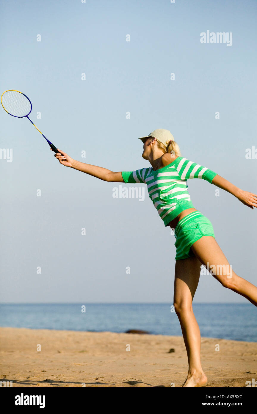 Young woman playing badminton on beach Stock Photo - Alamy