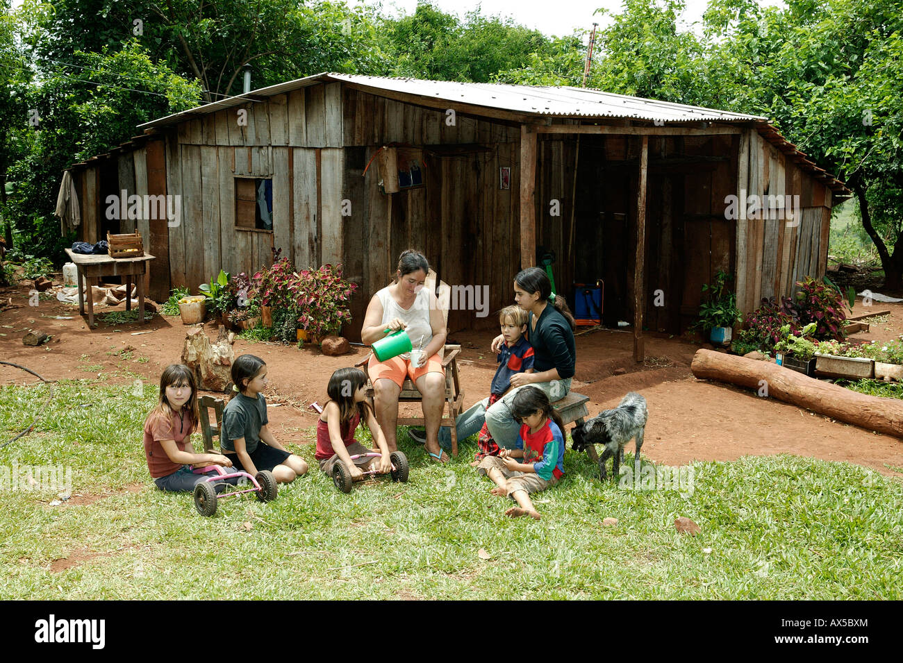 A group of women and children taking a break in front of their house, Paraguay, South America Stock Photo