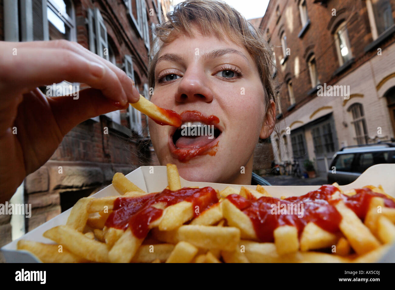 Young woman eats french fries with ketchup Stock Photo Alamy