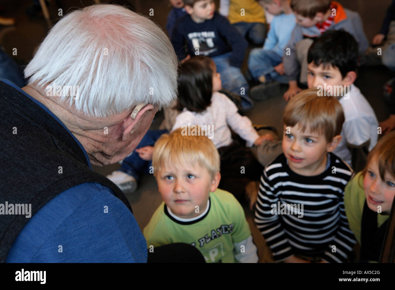 Old man, kindergarten children, listening, Baden-Wuerttemberg, Stuttgart Stock Photo