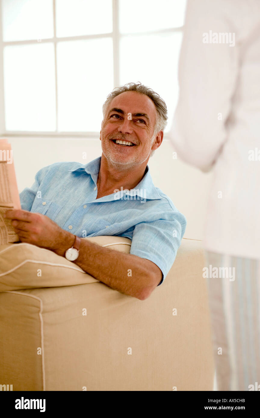 Mature couple in living room, man looking at woman, smiling Stock Photo