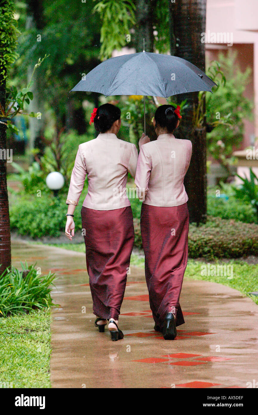 Two Thai young women walking under umbrela Phuket Thailand Asia Stock Photo